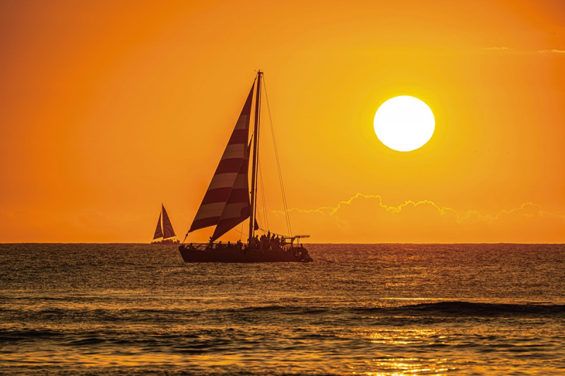 ハワイの海に静かに沈むオレンジ色の太陽